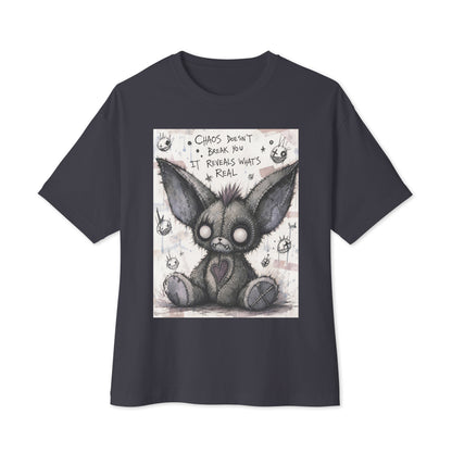Dark grey oversized boxy tee with the 'Chaos' goth graphic: a stitched gray big-eared creature with button eyes, with the words "Chaos doesn't break you, it reveals what's real"