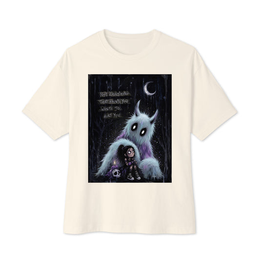 Natural oversized boxy tee with the 'The Haunted' goth graphic: a little goth girl holding a candle beside a fuzzy blue monster under a crescent moon, with the words "Not everything that haunts you wants to hurt you"