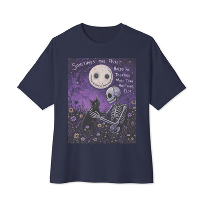 Navy oversized boxy tee with the 'The Quiet Heals' goth graphic: a skeleton and a black cat in a purple flower field under a smiling moon, with the words "Sometimes the quiet holds me together more than anything else"