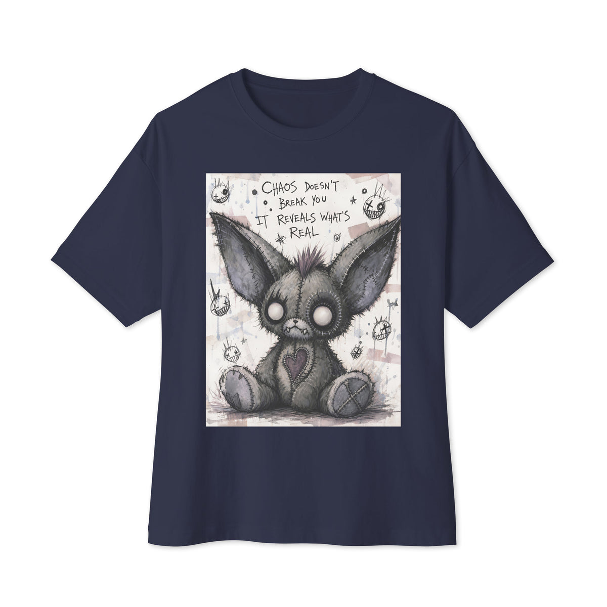 Navy oversized boxy tee with the 'Chaos' goth graphic: a stitched gray big-eared creature with button eyes, with the words "Chaos doesn't break you, it reveals what's real"