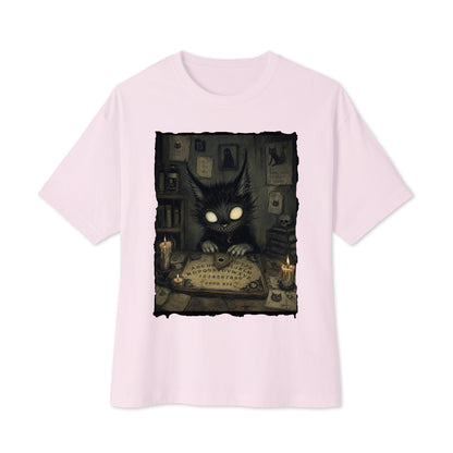 Soft pink oversized boxy tee with the 'Free Readings' goth graphic: a wide-eyed black cat creature at a Ouija board surrounded by candles