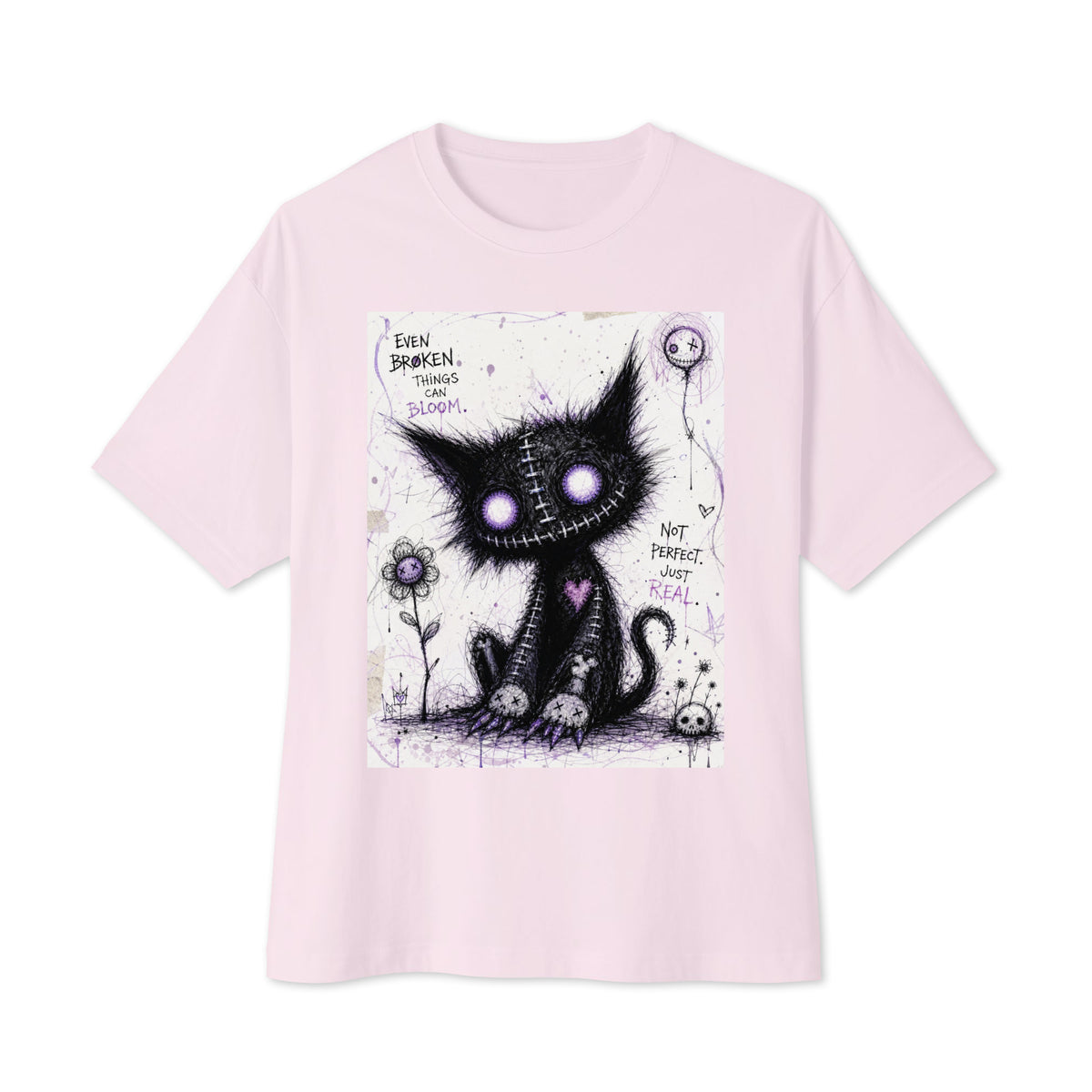 Soft pink oversized boxy tee with the 'Even Broken Things Can Bloom' goth graphic: a stitched black cat with glowing purple eyes beside a flower, with the words "Even broken things can bloom"