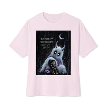 Soft pink oversized boxy tee with the 'The Haunted' goth graphic: a little goth girl holding a candle beside a fuzzy blue monster under a crescent moon, with the words "Not everything that haunts you wants to hurt you"