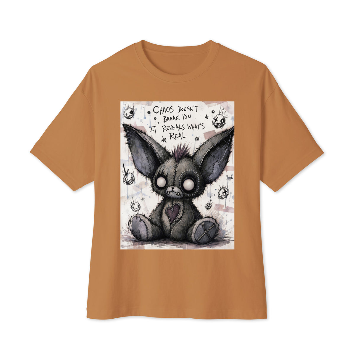 Toast oversized boxy tee with the 'Chaos' goth graphic: a stitched gray big-eared creature with button eyes, with the words "Chaos doesn't break you, it reveals what's real"