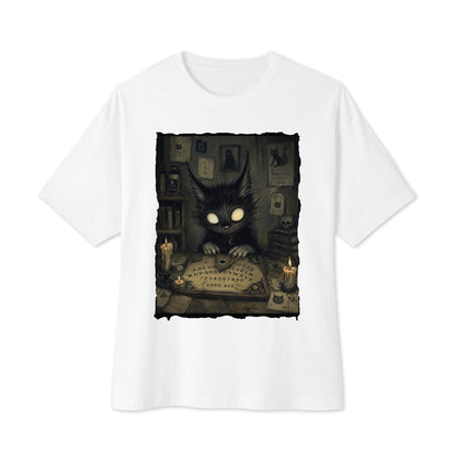 White oversized boxy tee with the 'Free Readings' goth graphic: a wide-eyed black cat creature at a Ouija board surrounded by candles