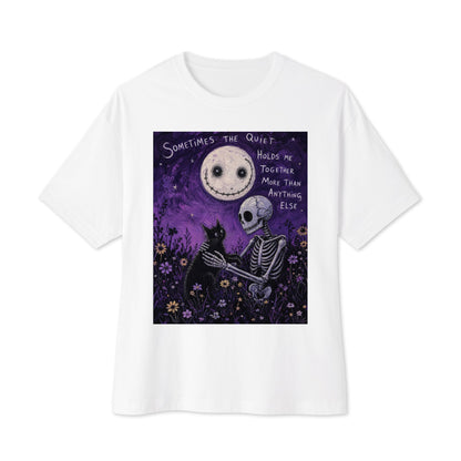 White oversized boxy tee with the 'The Quiet Heals' goth graphic: a skeleton and a black cat in a purple flower field under a smiling moon, with the words "Sometimes the quiet holds me together more than anything else"
