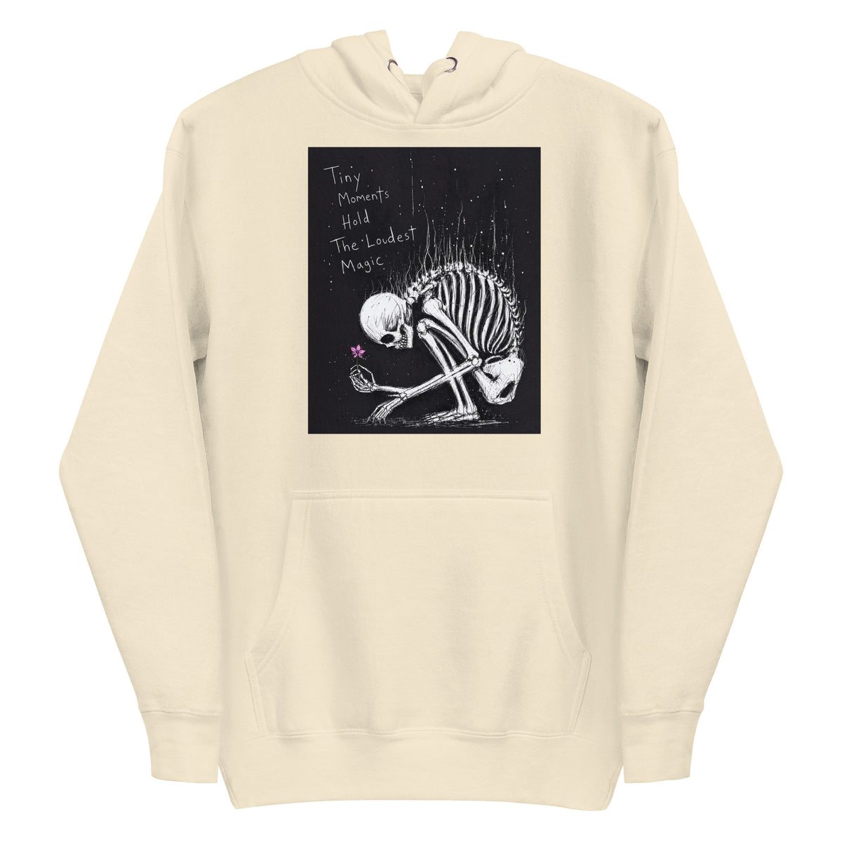 Bone pullover hoodie with the 'Tiny Moments' goth graphic: a kneeling skeleton holding a tiny pink flower on a black background, with the words "Tiny moments hold the loudest magic"