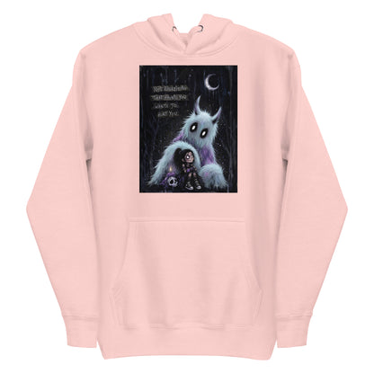 Light pink pullover hoodie with the 'The Haunted' goth graphic: a little goth girl holding a candle beside a fuzzy blue monster under a crescent moon, with the words "Not everything that haunts you wants to hurt you"