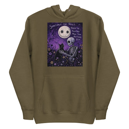 Military green pullover hoodie with the 'The Quiet Heals' goth graphic: a skeleton and a black cat in a purple flower field under a smiling moon, with the words "Sometimes the quiet holds me together more than anything else"
