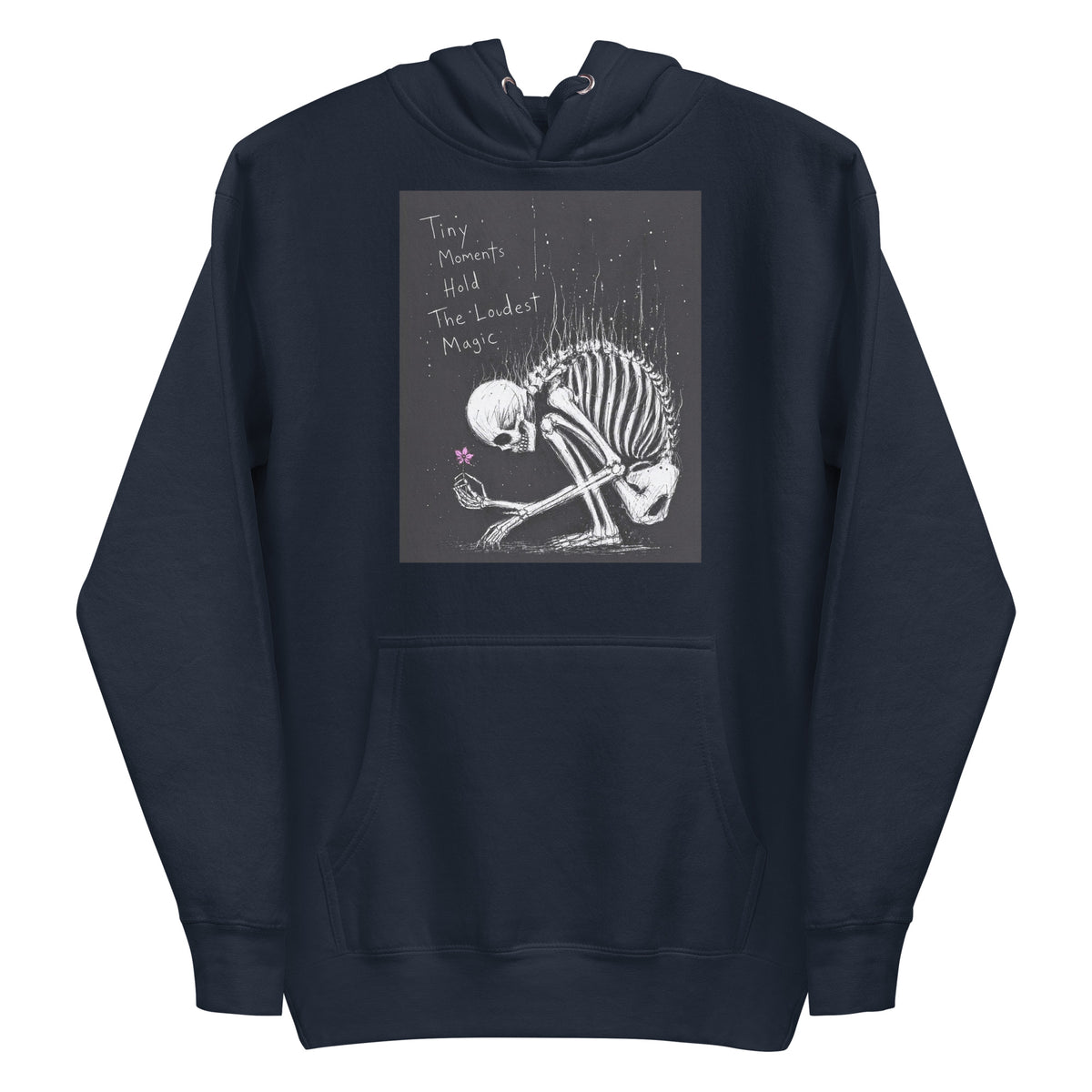 Navy pullover hoodie with the 'Tiny Moments' goth graphic: a kneeling skeleton holding a tiny pink flower on a black background, with the words "Tiny moments hold the loudest magic"
