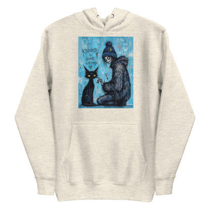 Oatmeal heather pullover hoodie with the 'Kindness Is Never Wasted' goth graphic: a girl in a moon beanie petting a black cat on a blue background, with the words "Kindness is never wasted"