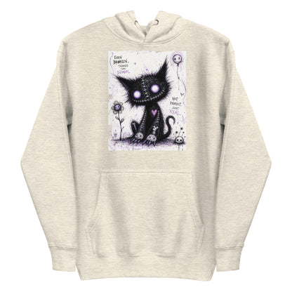 Oatmeal heather pullover hoodie with the 'Even Broken Things Can Bloom' goth graphic: a stitched black cat with glowing purple eyes beside a flower, with the words "Even broken things can bloom"