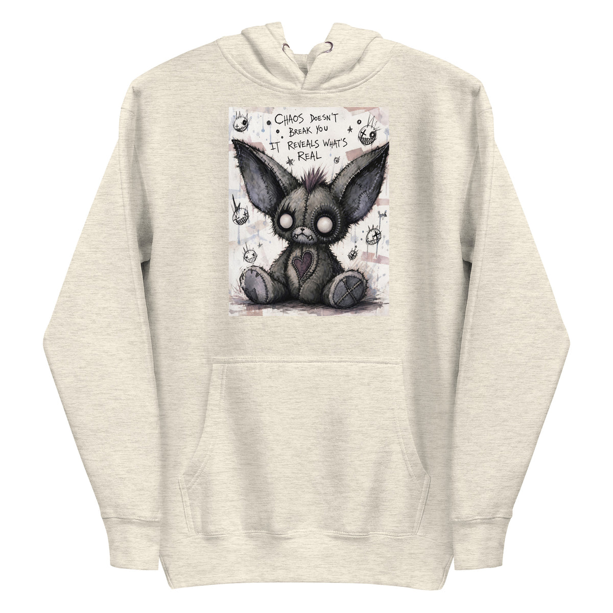 Oatmeal heather pullover hoodie with the 'Chaos' goth graphic: a stitched gray big-eared creature with button eyes, with the words "Chaos doesn't break you, it reveals what's real"