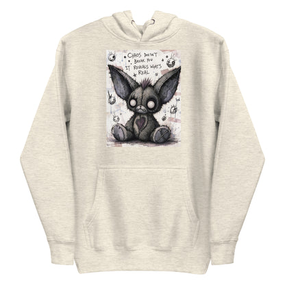 Oatmeal heather pullover hoodie with the 'Chaos' goth graphic: a stitched gray big-eared creature with button eyes, with the words "Chaos doesn't break you, it reveals what's real"