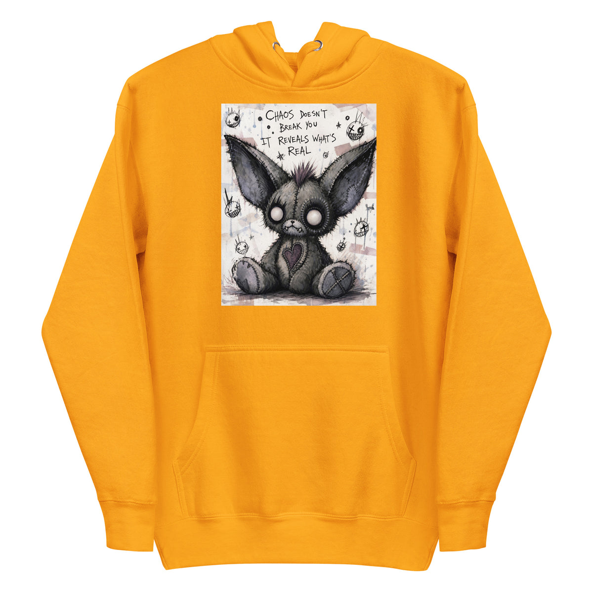 Gold pullover hoodie with the 'Chaos' goth graphic: a stitched gray big-eared creature with button eyes, with the words "Chaos doesn't break you, it reveals what's real"