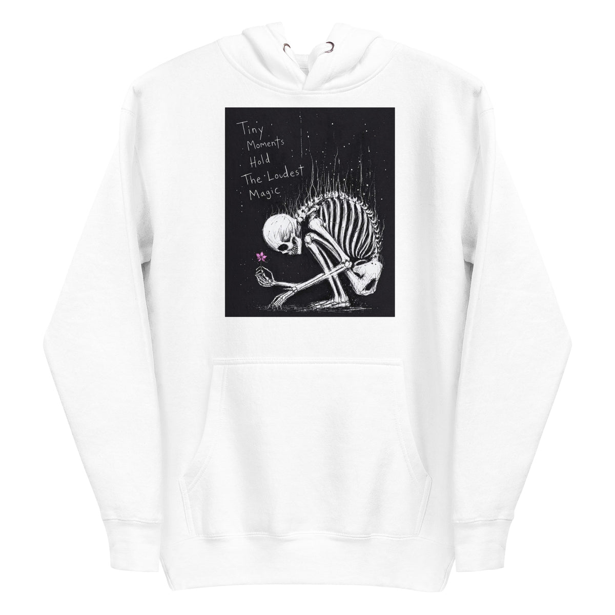 White pullover hoodie with the 'Tiny Moments' goth graphic: a kneeling skeleton holding a tiny pink flower on a black background, with the words "Tiny moments hold the loudest magic"