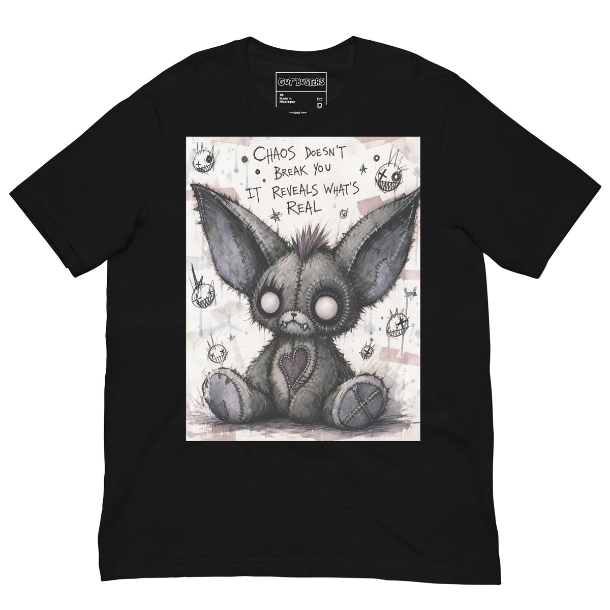 Black unisex t-shirt with the 'Chaos' goth graphic: a stitched gray big-eared creature with button eyes, with the words "Chaos doesn't break you, it reveals what's real"