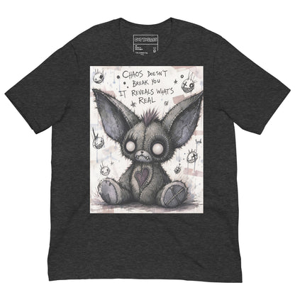 Dark grey heather unisex t-shirt with the 'Chaos' goth graphic: a stitched gray big-eared creature with button eyes, with the words "Chaos doesn't break you, it reveals what's real"