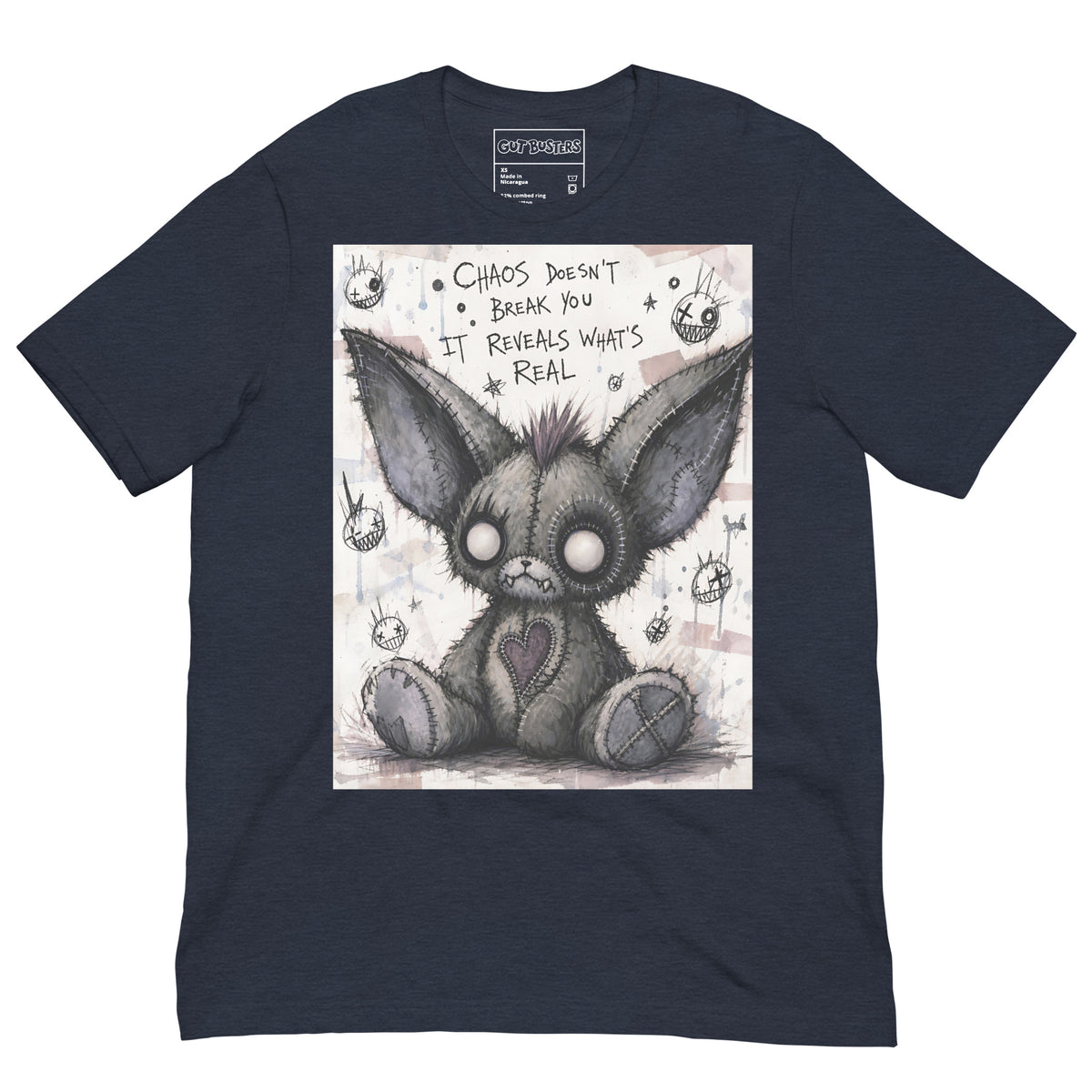 Heather navy unisex t-shirt with the 'Chaos' goth graphic: a stitched gray big-eared creature with button eyes, with the words "Chaos doesn't break you, it reveals what's real"