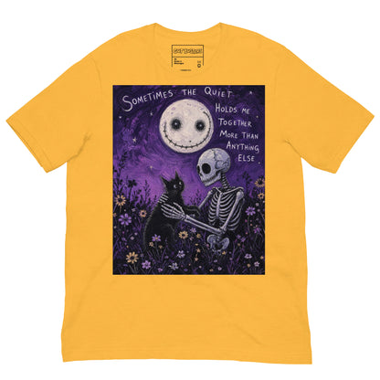 Heather yellow unisex t-shirt with the 'The Quiet Heals' goth graphic: a skeleton and a black cat in a purple flower field under a smiling moon, with the words "Sometimes the quiet holds me together more than anything else"