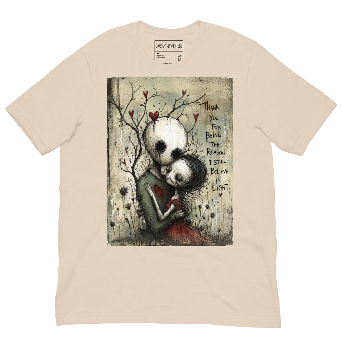 Soft cream unisex t-shirt with the 'My Light In Dark Places' goth graphic: a skull-faced couple embracing under a bare tree with red hearts, with the words "Thank you for being the reason I still believe in light"