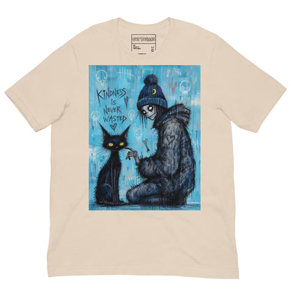 Soft cream unisex t-shirt with the 'Kindness Is Never Wasted' goth graphic: a girl in a moon beanie petting a black cat on a blue background, with the words "Kindness is never wasted"