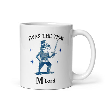 White glossy mug with blue knight sword graphic and 'Twas the Tism' header, 'M'Lord' bottom