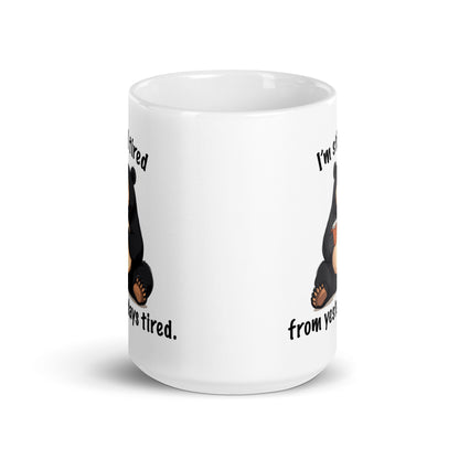 White mug back view with partial bear illustration and tired wording