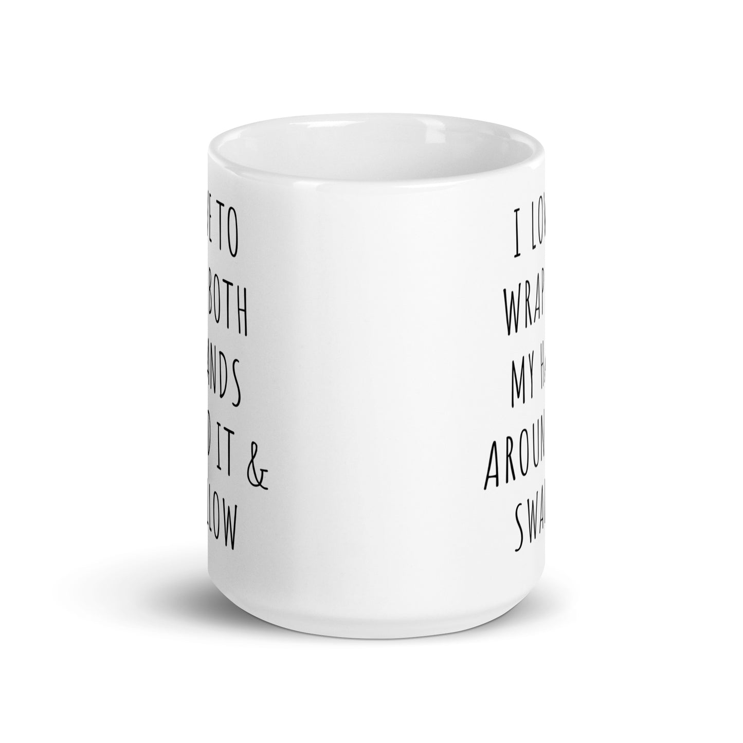 White glossy ceramic mug side view with partial black quote: WRAP BOTH MY HANDS
