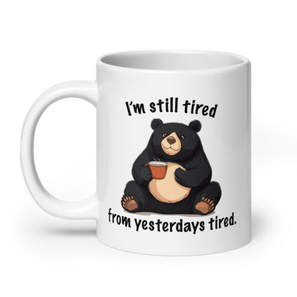 White glossy mug with black bear holding coffee and “I'm still tired” text