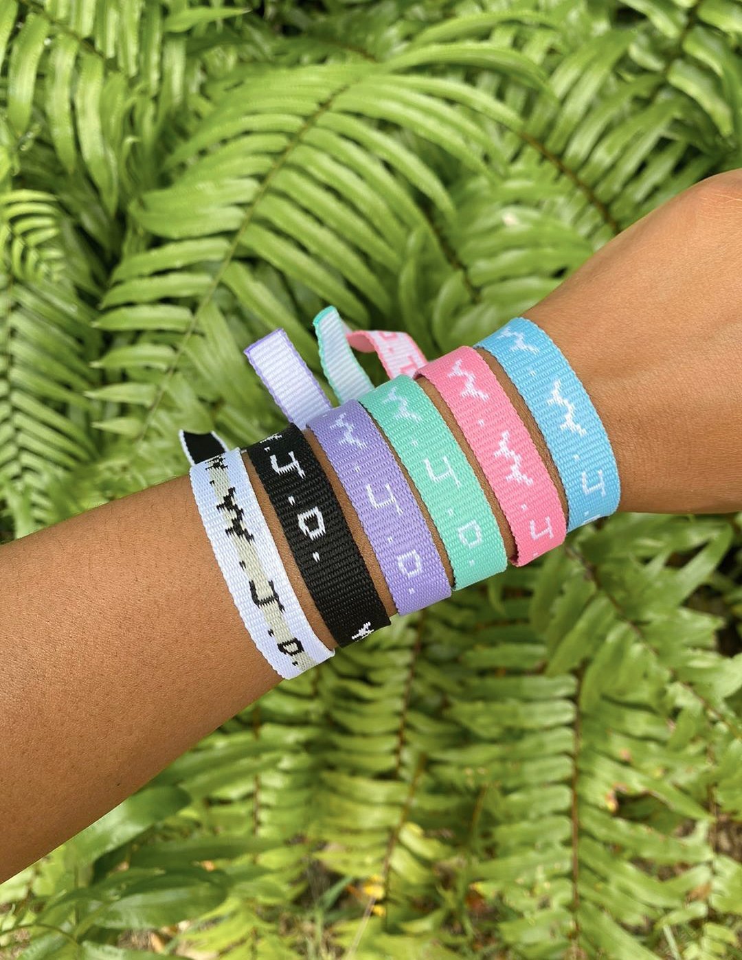 Colorful Elevated Faith Christian Jewelry Bracelet set displayed on a wrist among green leaves