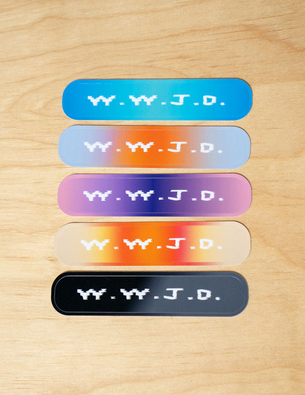Set of five colorful Christian Stickers featuring the phrase W.Y.J.D. on a wooden background