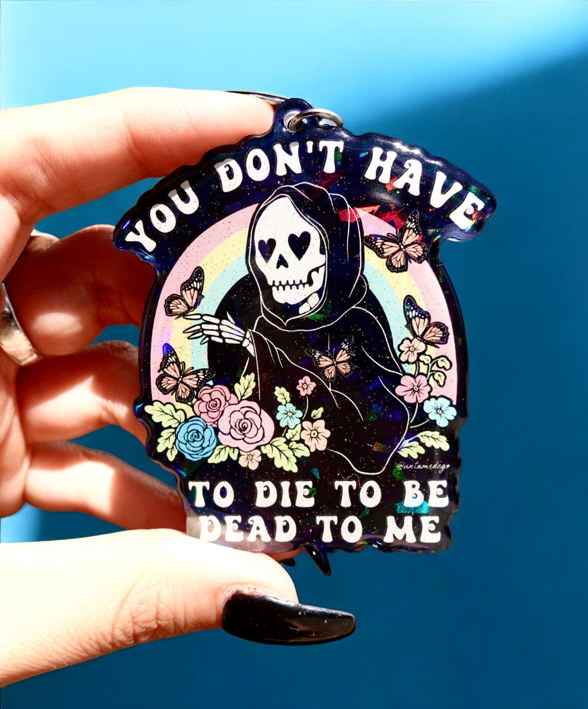 Funny Skull graphic enamel keychain with flowers and butterfly, dark purple background